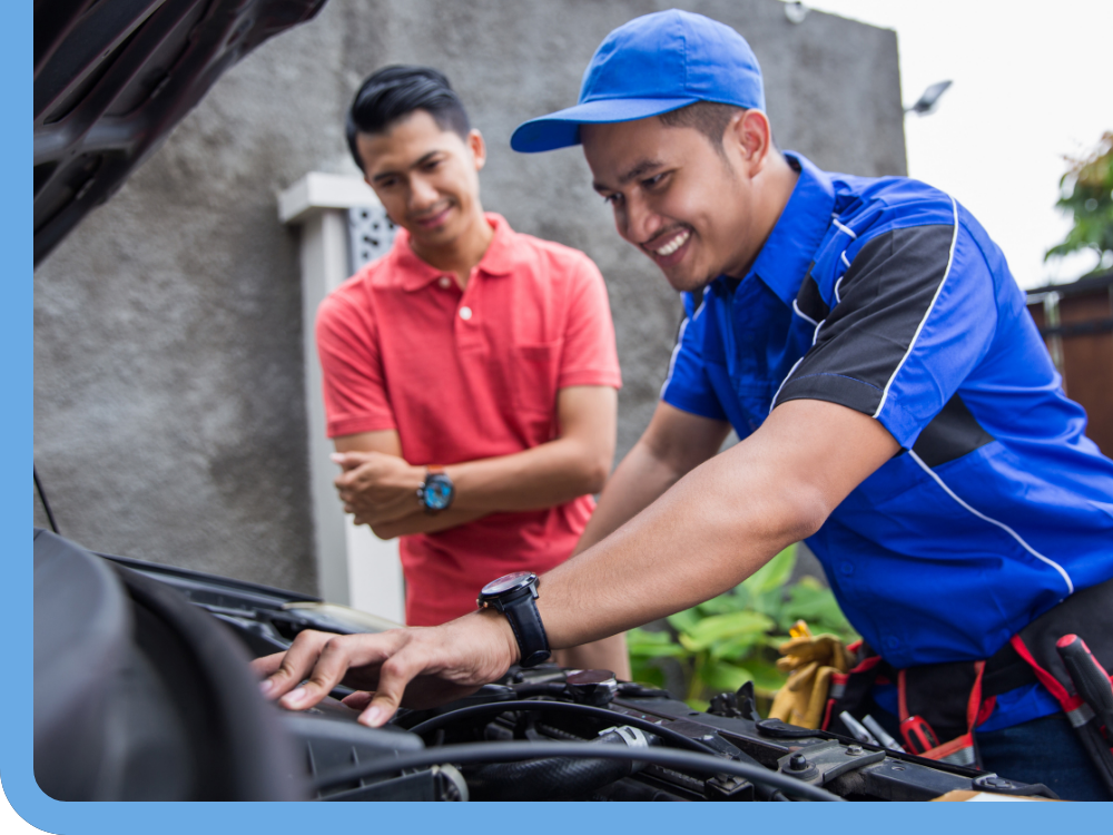 mechanic working on engine while client watches