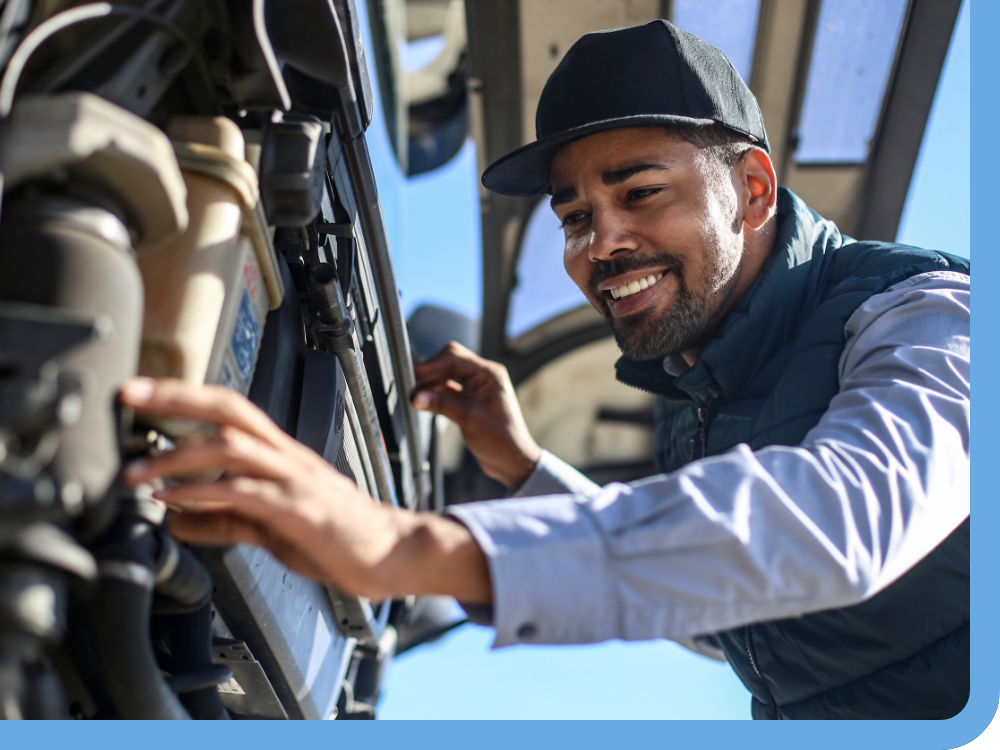 smiling technician working on engine